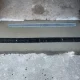 Channel drain grate set into a concrete driveway apron